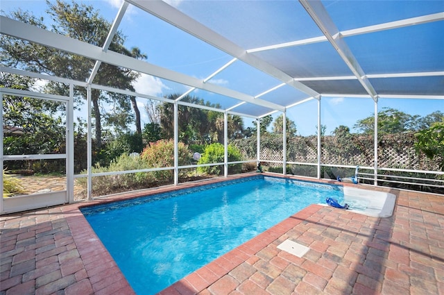 pool featuring glass enclosure and a patio area