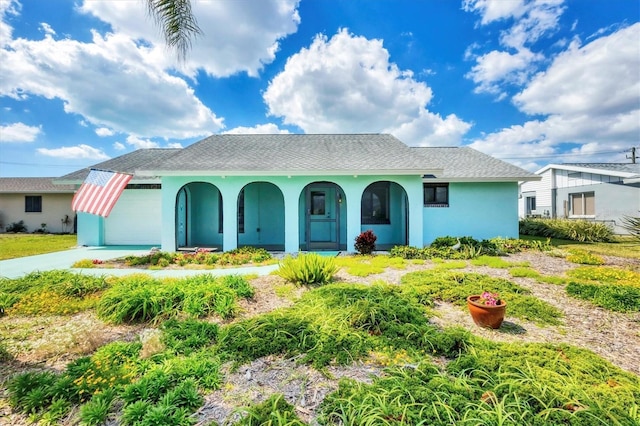 view of front of house featuring an attached garage, driveway, and stucco siding