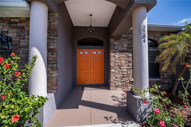 property entrance with stone siding and stucco siding