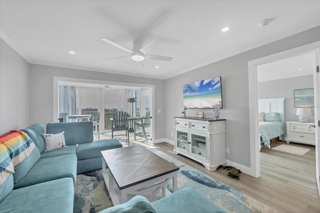 living room featuring light wood-type flooring, baseboards, ornamental molding, and ceiling fan