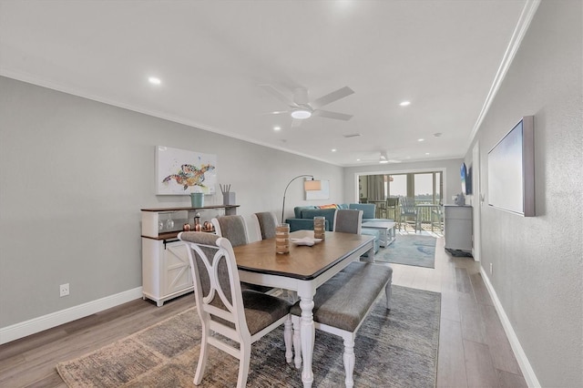 dining space featuring crown molding, baseboards, wood finished floors, and recessed lighting