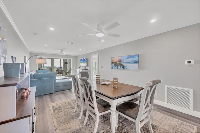 dining area with a ceiling fan, visible vents, crown molding, and light wood finished floors