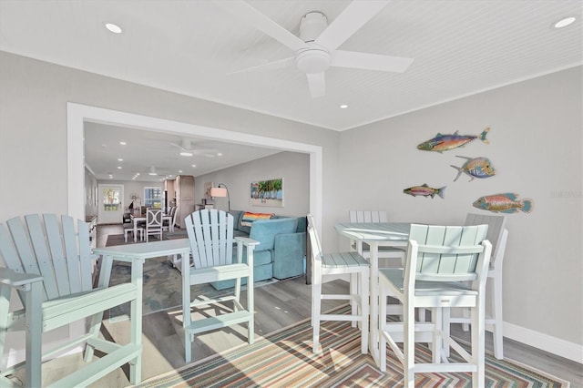 dining space featuring baseboards, wood finished floors, a ceiling fan, and recessed lighting