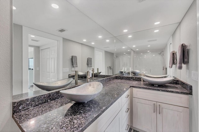 full bath with visible vents, a sink, and double vanity