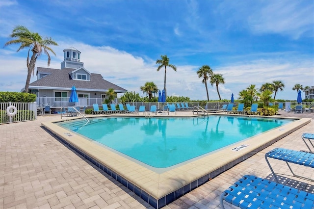 pool featuring fence and a patio