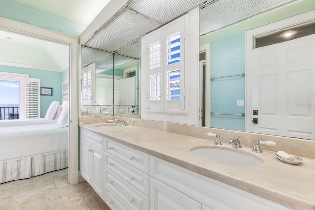 bathroom with ensuite bathroom, double vanity, a sink, and tile patterned floors