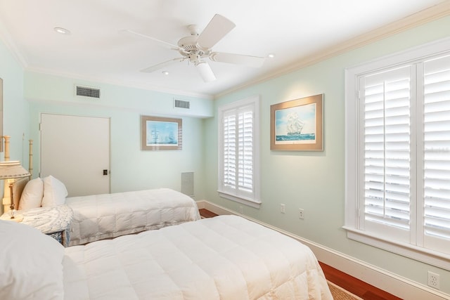 bedroom with baseboards, visible vents, and crown molding