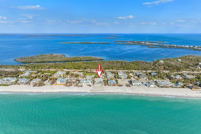 drone / aerial view featuring a water view and a view of the beach