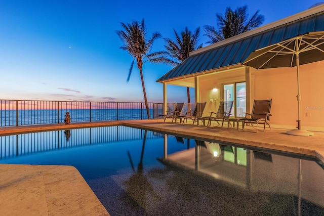 view of pool featuring a patio area, a fenced in pool, and a water view