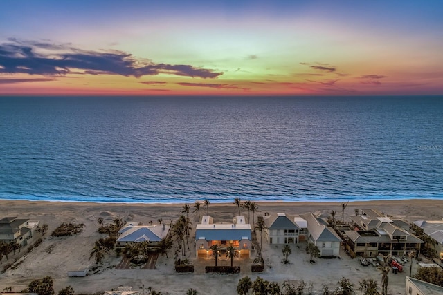 aerial view at dusk with a view of the beach, a residential view, and a water view