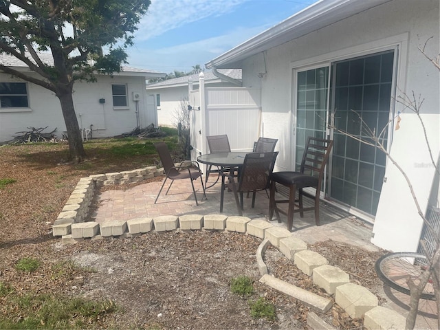 view of patio featuring outdoor dining space and fence