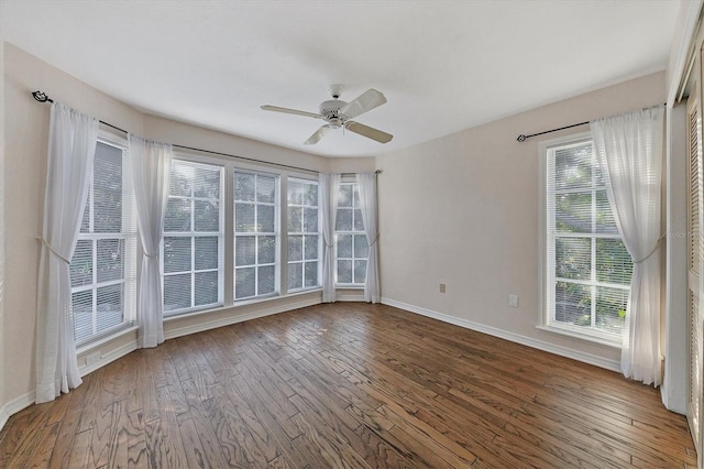 empty room with wood-type flooring, baseboards, and a ceiling fan