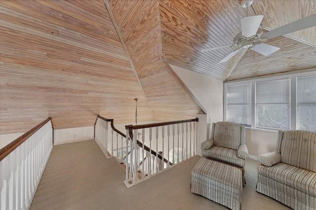 unfurnished room with wooden ceiling, an upstairs landing, a ceiling fan, vaulted ceiling, and carpet