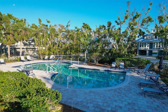 pool with a patio area and fence