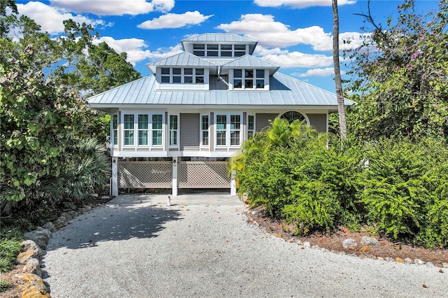 view of front of house with metal roof, driveway, a carport, and a standing seam roof