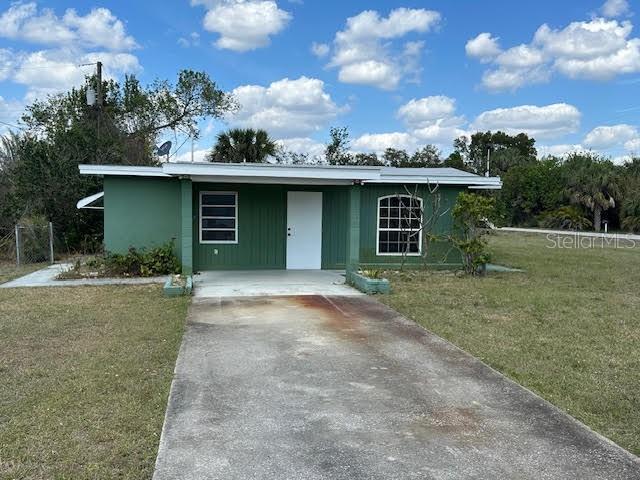 view of front of house featuring concrete driveway and a front lawn