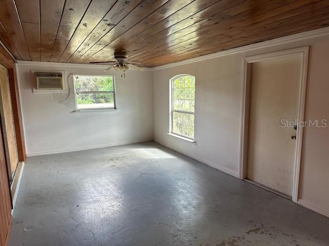 1417 Terry Ave, Punta Gorda, FL 33980 - unfurnished room with wood ceiling, a wall unit AC, ceiling fan, and finished concrete flooring