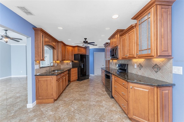 kitchen with visible vents, a sink, black appliances, glass insert cabinets, and brown cabinets