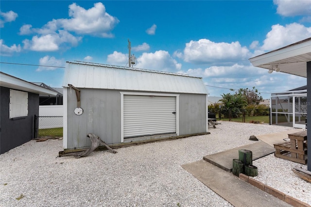 garage with a storage shed and fence