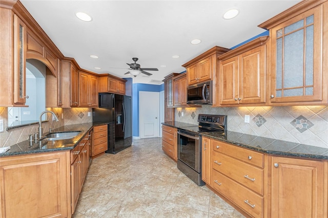 kitchen featuring glass insert cabinets, brown cabinets, appliances with stainless steel finishes, and a sink