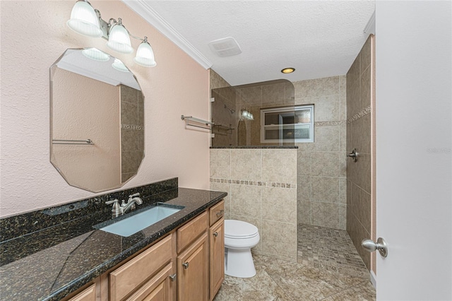 bathroom featuring a textured ceiling, toilet, vanity, and a walk in shower