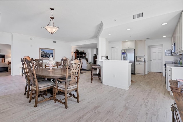 dining room featuring ornamental molding, light wood-style flooring, visible vents, and recessed lighting