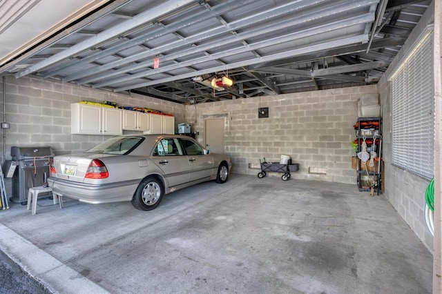 garage with concrete block wall and a garage door opener