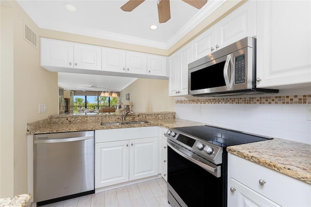 kitchen featuring stainless steel appliances, visible vents, backsplash, ornamental molding, and a sink