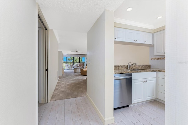 kitchen with light stone countertops, a sink, white cabinets, decorative backsplash, and dishwasher