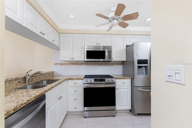 kitchen with tasteful backsplash, appliances with stainless steel finishes, ornamental molding, white cabinets, and a sink