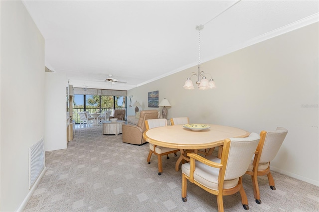 dining room with visible vents, ornamental molding, light carpet, baseboards, and ceiling fan with notable chandelier