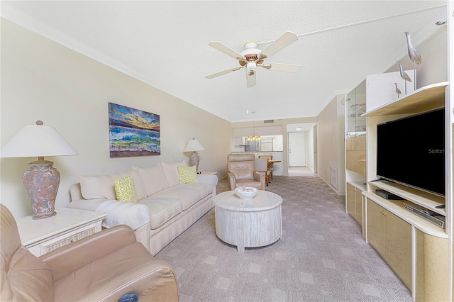 living area featuring ceiling fan with notable chandelier, crown molding, visible vents, and light colored carpet