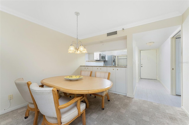 dining room featuring a notable chandelier, light carpet, visible vents, baseboards, and ornamental molding