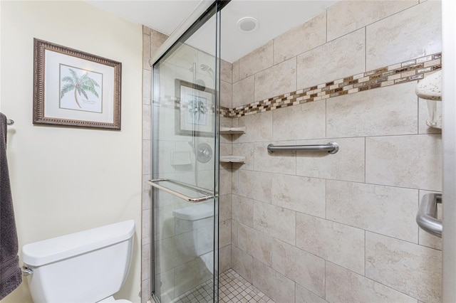 bathroom featuring a stall shower and toilet