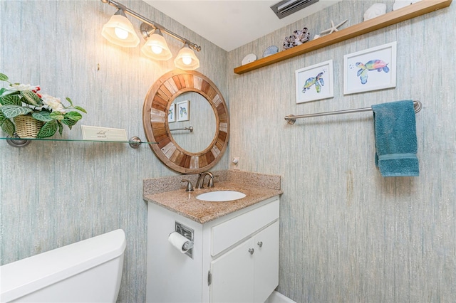 bathroom featuring visible vents, vanity, and toilet