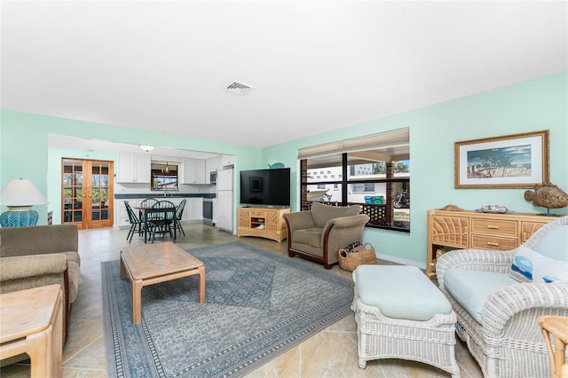 living room with baseboards, visible vents, and french doors