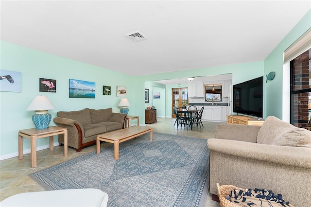 living room featuring baseboards and visible vents