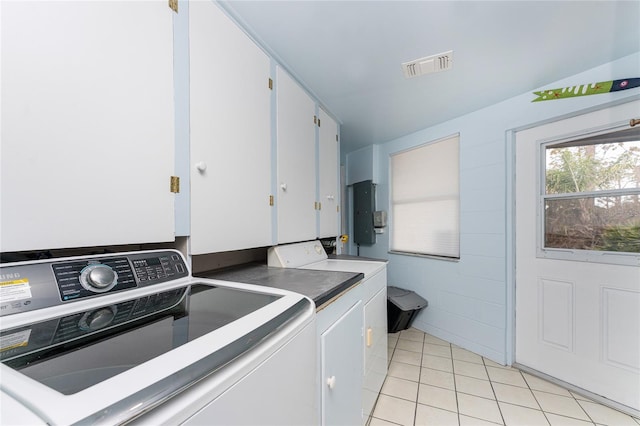 laundry area with light tile patterned floors, cabinet space, visible vents, electric panel, and independent washer and dryer