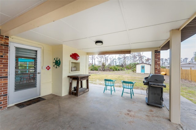 view of patio with a shed, an outdoor structure, grilling area, and fence