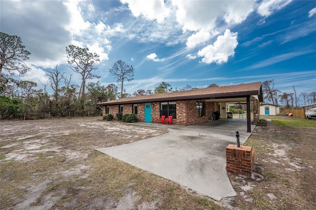 view of front of house featuring a carport, brick siding, and driveway