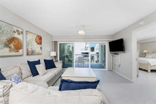 living room with ceiling fan and baseboards