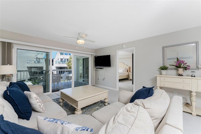 living room featuring a ceiling fan and baseboards