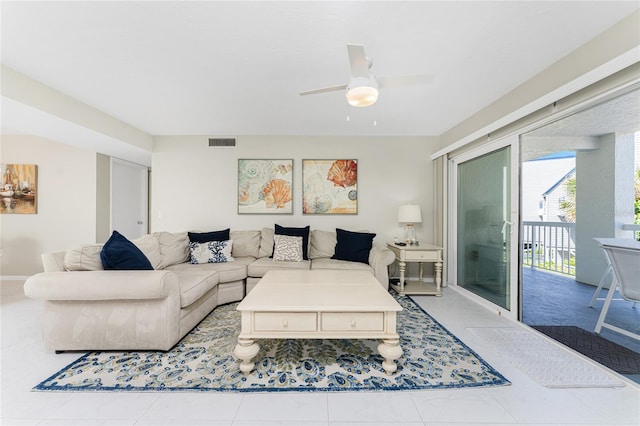 living area featuring ceiling fan, visible vents, and baseboards