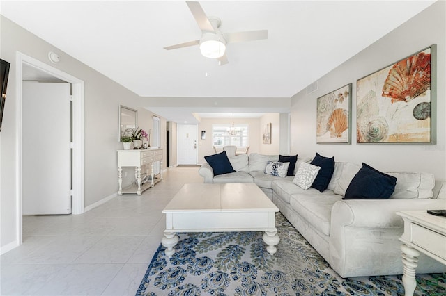 living area with light tile patterned flooring, baseboards, visible vents, and ceiling fan with notable chandelier