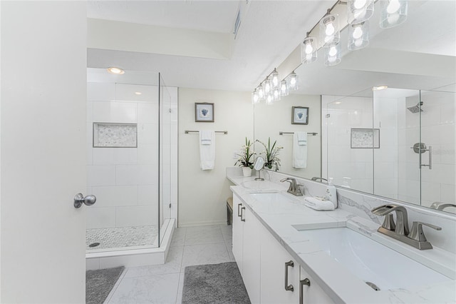 bathroom featuring marble finish floor, a shower stall, and a sink