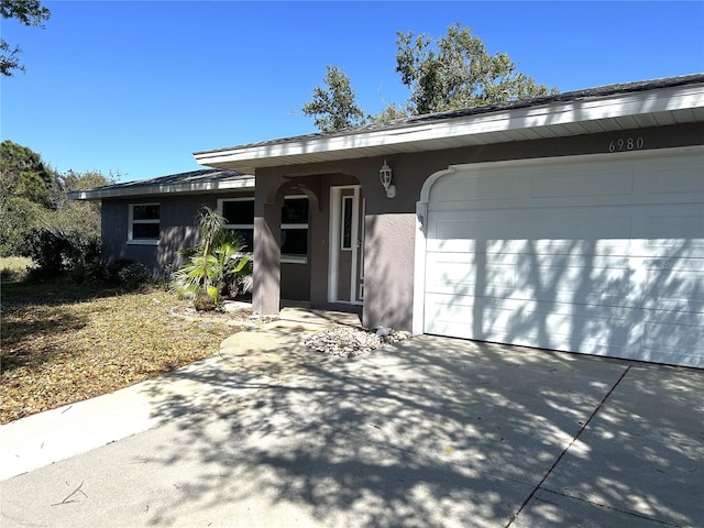 view of front of house featuring a garage, driveway, and stucco siding