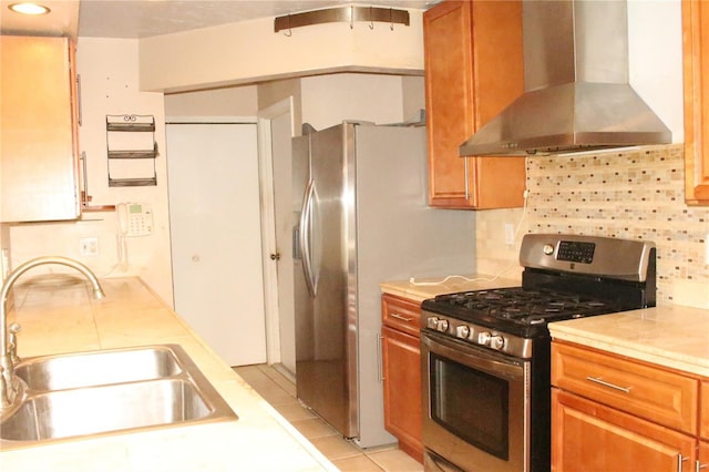 kitchen with a sink, backsplash, stainless steel range with gas stovetop, and wall chimney exhaust hood