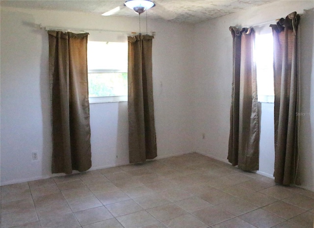 spare room featuring light tile patterned floors and a healthy amount of sunlight