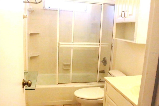 bathroom featuring combined bath / shower with glass door, toilet, and vanity