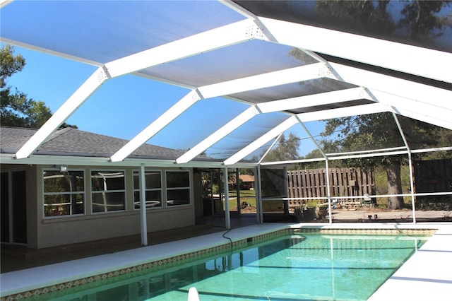 outdoor pool featuring glass enclosure and a patio area